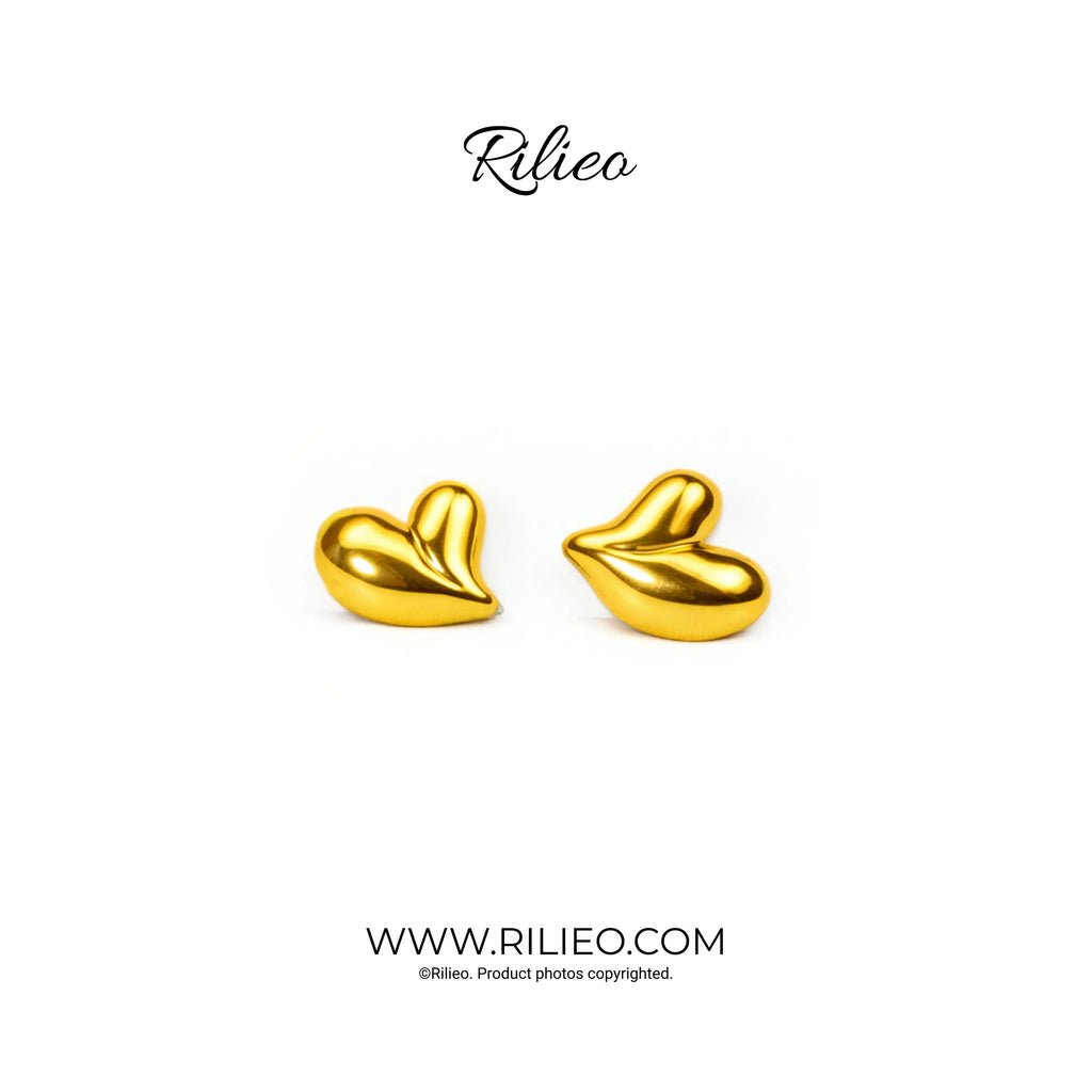 Gold plated heart-shaped stud earrings on white background