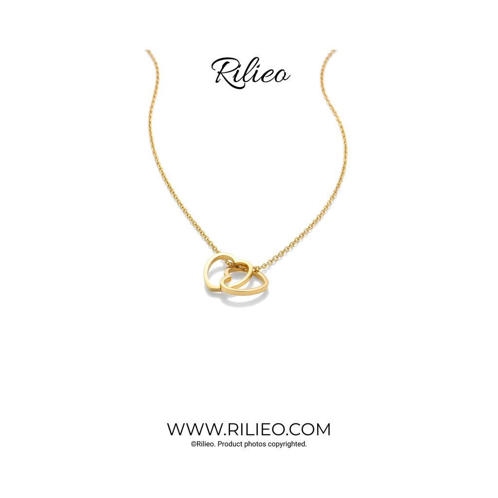 Gold plated necklace with two interlocking heart pendants on a white background