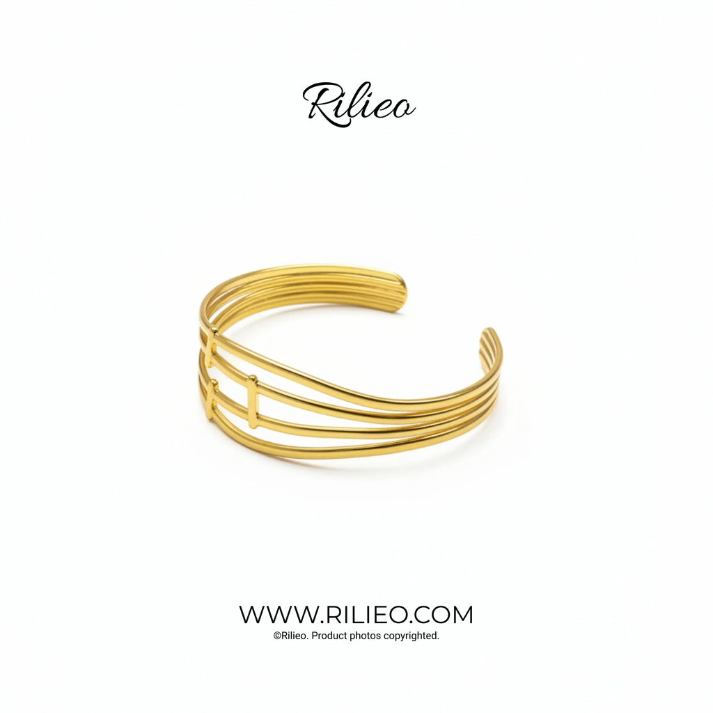 Modern gold plated open cuff bracelet with minimalist multi-band design on white background