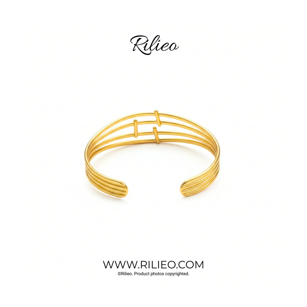 Gold plated open cuff bracelet with modern triple bar design on white background